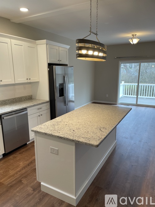 A kitchen with a granite countertop and a refrigerator.