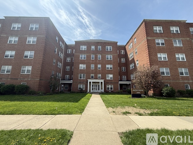 A large brick building with a walkway in front and a sign that says "AVAILABLE".