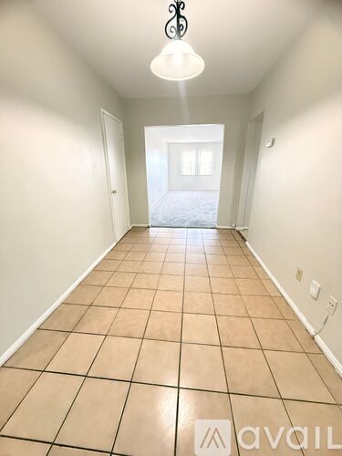 A long hallway with tiled floors and white walls.