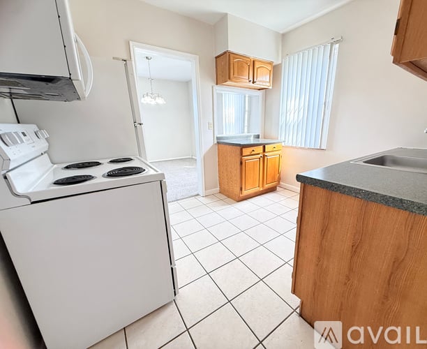 A kitchen with a white stove top oven and a wooden counter.