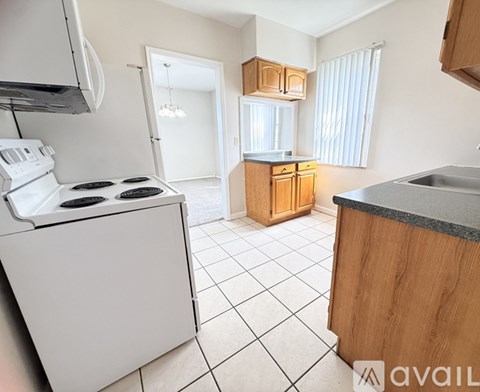 A kitchen with a white stove top oven and a wooden counter.