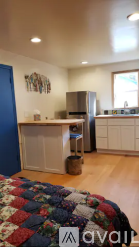 A kitchen with a refrigerator, sink, and cabinets.