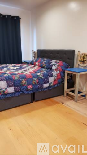 A bedroom with a bed and a small table.