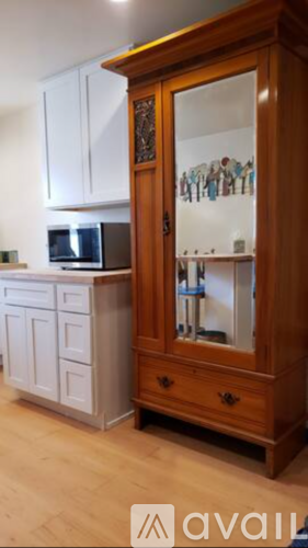 A wooden cabinet with glass doors is in the foreground.