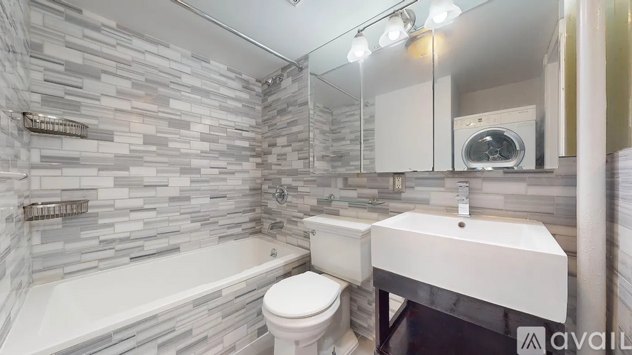 A bathroom with a white tub, toilet, and sink.