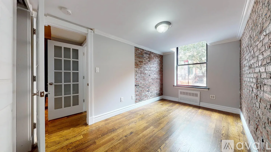 A room with a brick wall and wooden flooring.