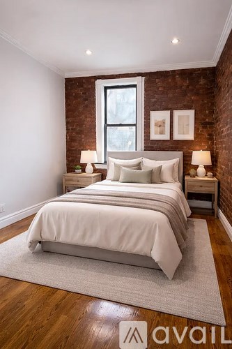 A bedroom with a large bed and a brick wall.