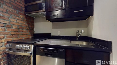 A kitchen with a brick wall and a stainless steel oven.