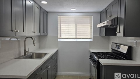 A kitchen with a stove top oven and a sink.