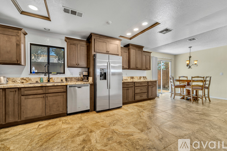A kitchen with brown cabinets and a marble floor.