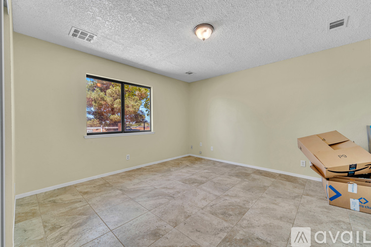A room with a tiled floor and a window showing trees outside.