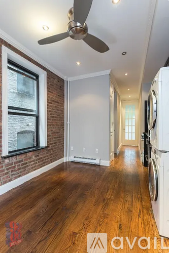 A room with a fan and a washing machine.