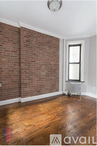 A room with a brick wall and a window with a radiator under it.