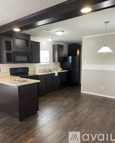 A kitchen with dark brown cabinets and a countertop.