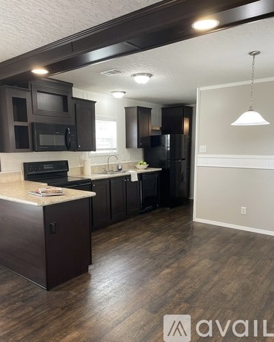 A kitchen with dark brown cabinets and a countertop.