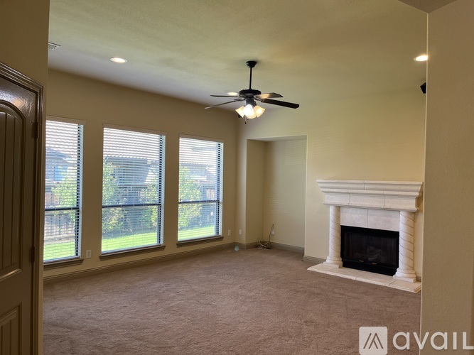 A living room with a fireplace and a ceiling fan.