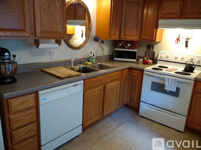 A kitchen with wooden cabinets and a white dishwasher.