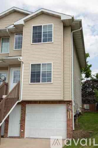 A two-story house with a garage on the bottom floor.