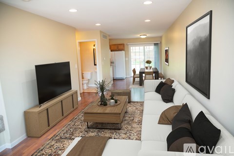 A living room with a white couch and a flat screen TV.