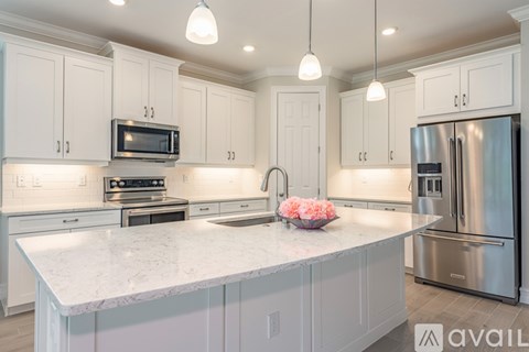 A kitchen with white cabinets and a marble countertop.
