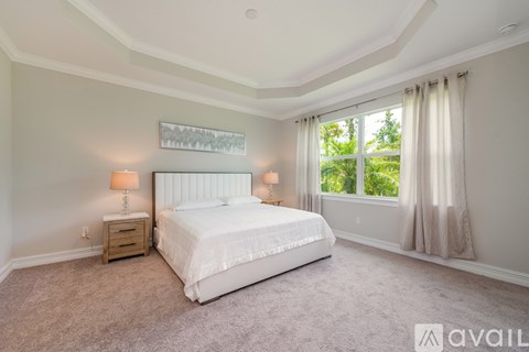 A bedroom with a large bed and two lamps.