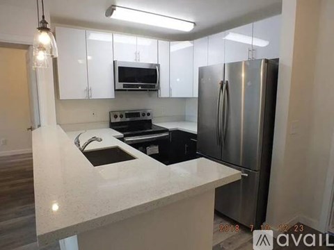 A kitchen with a stove top oven and a refrigerator.