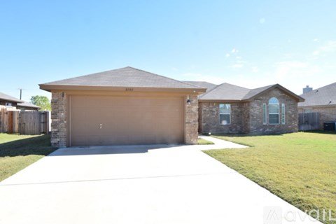 A house with a garage and driveway in front of it.