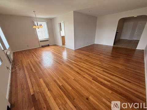 A room with wooden flooring and white walls.