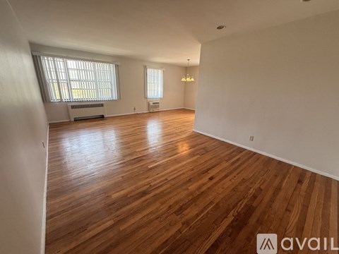 A room with wooden flooring and white walls.