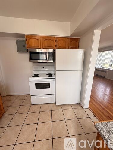 A kitchen with white appliances and wooden cabinets.