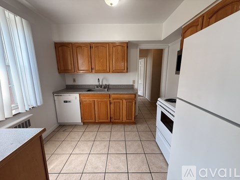 A kitchen with white appliances and wooden cabinets.