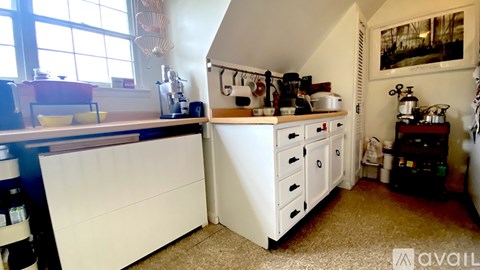A kitchen with white cabinets and a window.