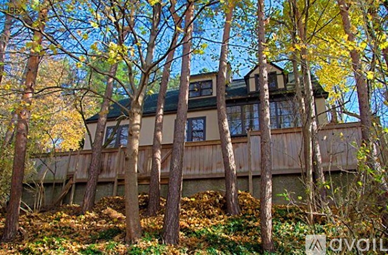 A house surrounded by trees with yellow leaves.