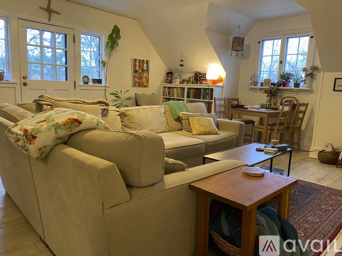 A living room with a couch, a coffee table, and a rug.
