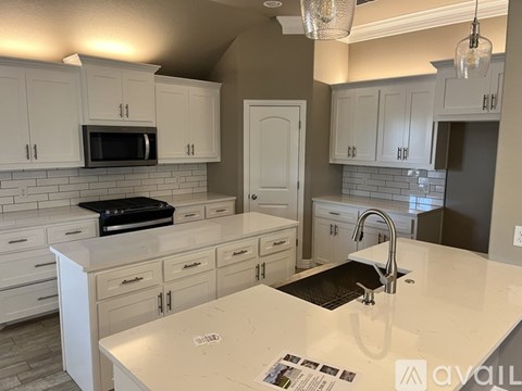 A kitchen with white cabinets and a white countertop.