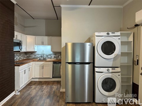 A kitchen with a washer and dryer stacked on top of each other.