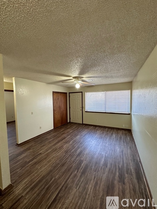 A room with wooden floors and a ceiling fan.