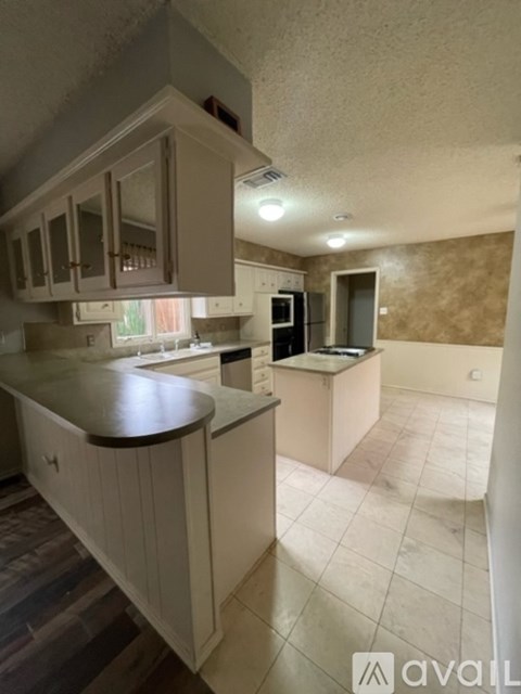 A kitchen with white cabinets and a countertop.