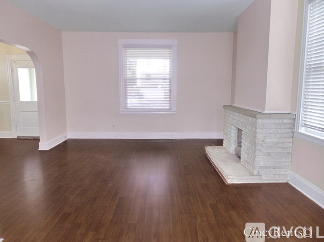 A room with a fireplace and wooden floors.