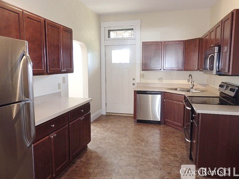 A kitchen with brown cabinets and a white door.