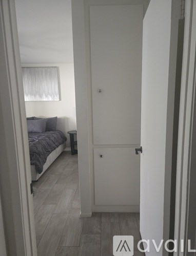 A small bedroom with a bed and a window.