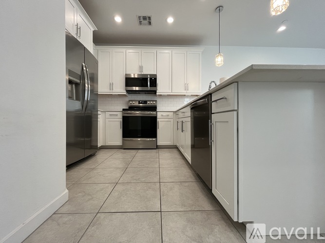 A kitchen with white cabinets and stainless steel appliances.