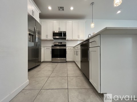 A kitchen with white cabinets and stainless steel appliances.