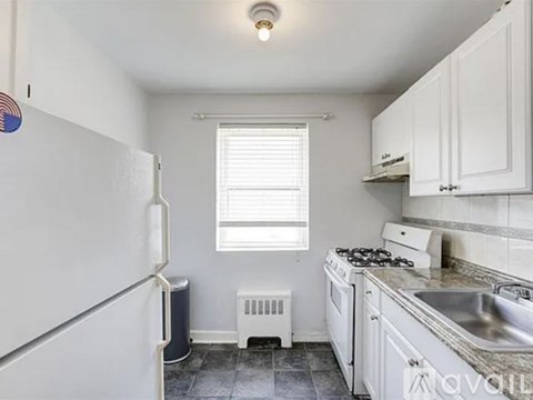 A kitchen with white cabinets and a white fridge.