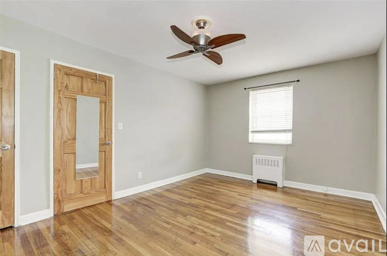 A room with a ceiling fan and wooden floors.