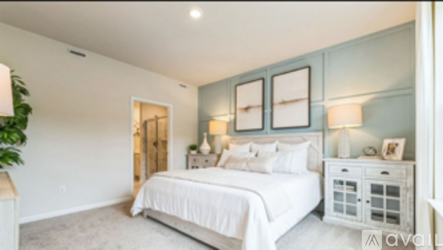 A bedroom with a large bed and a white dresser.
