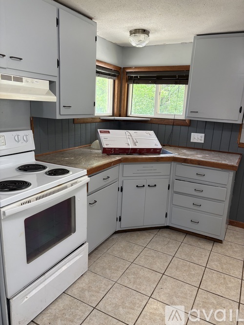 A kitchen with white appliances and cabinets.