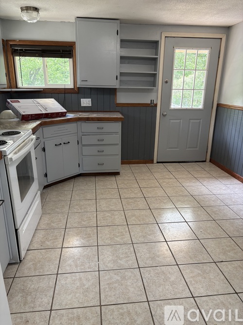A kitchen with white appliances and a white stove top oven.