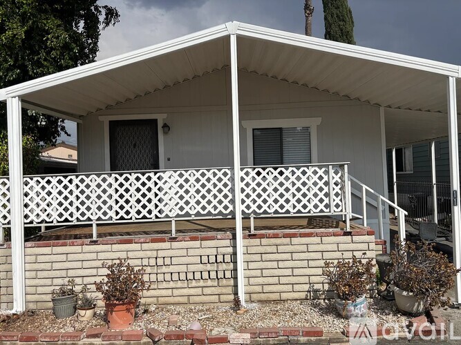 A white house with a porch and a white fence.