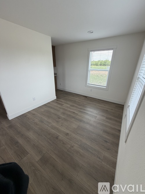 A room with a window and wooden flooring.